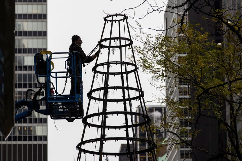 Workers clean up the burnt remains of a Christmas tree outside the News Corp. and Fox News building in New York