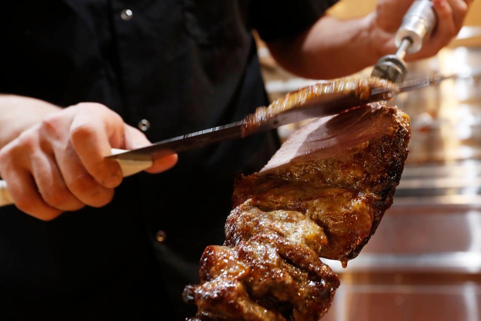 A leg of lamb is carved at the carving station at Flama Brazilian Steak House in Athens, Ga., on Thursday, Feb. 29, 2024. Flama offers several cuts of beef, lamb, chicken and pork.