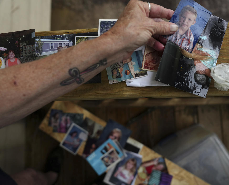 Dorothy Blevins dries out photos from her home after it was flooded by the East Branch San Jacinto River on Sunday, May 5, 2024, in Spendora, Texas. "These mean the most to me, everything else can be replaced," she said. Two weeks ago, her husband, Earl, closed their storage rental and put everything in their new home. "The timing of this is terrible," he said. (Elizabeth Conley/Houston Chronicle via AP)