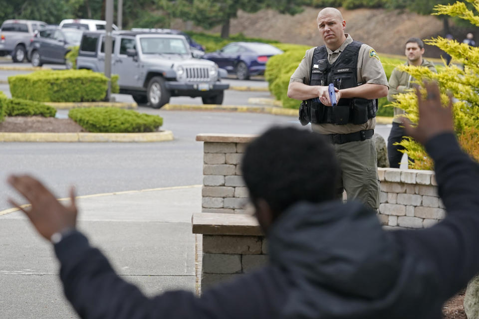 Kevin Burton-Crow, right, of the Thurston Co. Sheriff's Dept., points a training gun at Naseem Coaxum, an actor playing the role of a person causing a disturbance at a convenience store, during a training class at the Washington state Criminal Justice Training Commission, Wednesday, July 14, 2021, in Burien, Wash. Washington state is embarking on a massive experiment in police reform and accountability following the racial justice protests that erupted after George Floyd's murder last year, with nearly a dozen new laws that took effect Sunday, July 25, but law enforcement officials remain uncertain about what they require in how officers might respond — or not respond — to certain situations, including active crime scenes and mental health crises. (AP Photo/Ted S. Warren)