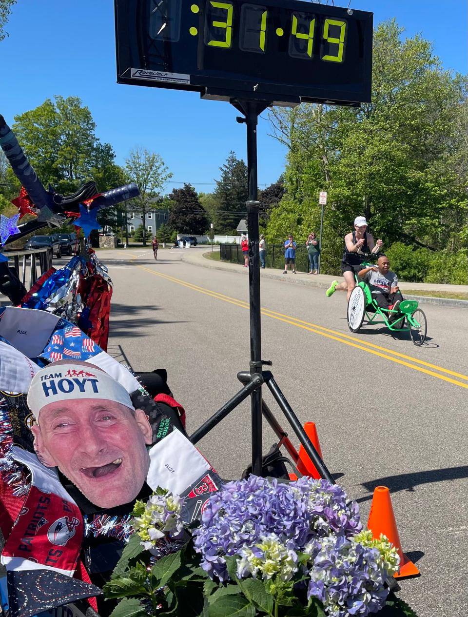 Brendan Aylward pushing Jacob Wyman cross as the first ‘duo’ finishers at the inaugural Dick Hoyt Memorial Yes You Can Race in Hopkinton on Saturday.