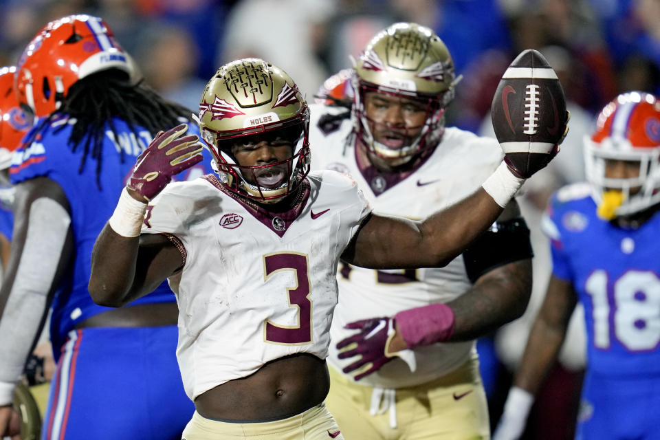 Florida State running back Trey Benson (3) viert zijn run van 1 meter tegen Florida tijdens de eerste helft van een NCAA-voetbalwedstrijd op zaterdag 25 november 2023 in Gainesville, Florida. (AP Photo/John Raoux)