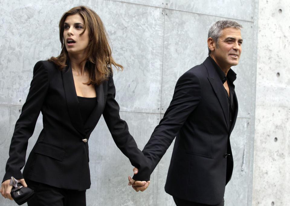 FILE - In this Sept. 27, 2010 file photo, American actor George Clooney holds hands with his girlfriend Elisabetta Canalis prior to the presentation of the Armani Spring-Summer 2011 fashion collection, during the fashion week in Milan, Italy. Clooney, 52, Hollywood’s most determined bachelor famous for a litany of fleeting loves, has taken himself off the romantic market and proposed to 36-year-old attorney, Amal Alamuddin. A spokesman for the Oscar-winning actor and producer did not respond to requests for comment Monday, April 28, 2014. (AP Photo/Luca Bruno, file)