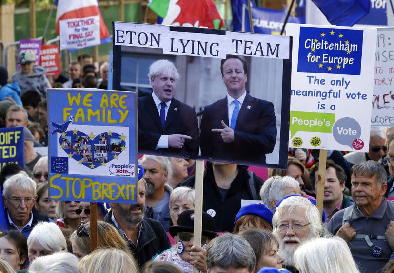 EU supporters hold a placard showing former prime ministers Boris Johnson and David Cameron as they take part in a People's Vote' protest march in London, 2019