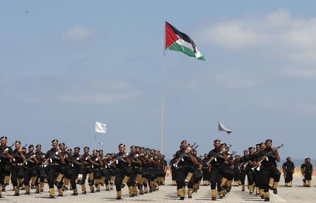 A Palestinian flag flutters as Palestinian policemen loyal to Hamas march during a military graduation ceremony in Gaza City June 16, 2015. REUTERS/Suhaib Salem - RTX1GOO4
