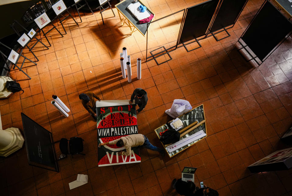 Varios trabajadores preparan obras para una exposición llamada “Desde todos los ríos hasta todos los mares. Gráfica en Solidaridad con Palestina” en el Archivo Nacional de Chile en Santiago, Chile, el miércoles 19 de junio de 2024. (AP Foto/Esteban Félix)