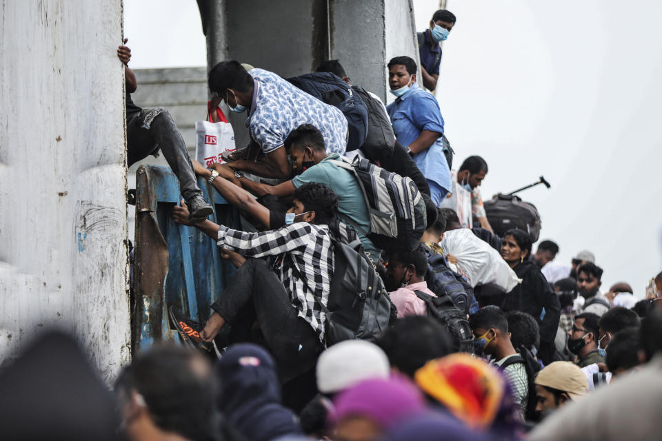 Thousands of people leaving for their native places to celebrate Eid-al-Fitr crowd the Mawa ferry terminal ignoring risks of coronavirus infection in Munshiganj, Bangladesh, Thursday, May 13, 2021. (AP Photo/Mahmud Hossain Opu)