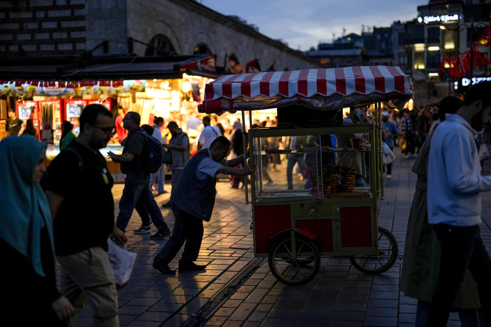 A bread street vendor pushes his wheeled stand at Eminonu commercial area in Istanbul, Turkey, Friday, Nov. 3, 2023. Turkey is marking its centennial but a brain drain is casting a shadow on the occasion. Government statistics indicate that a growing number of the young and educated are looking to move abroad in hopes of a better life, mainly in Europe. (AP Photo/Francisco Seco)