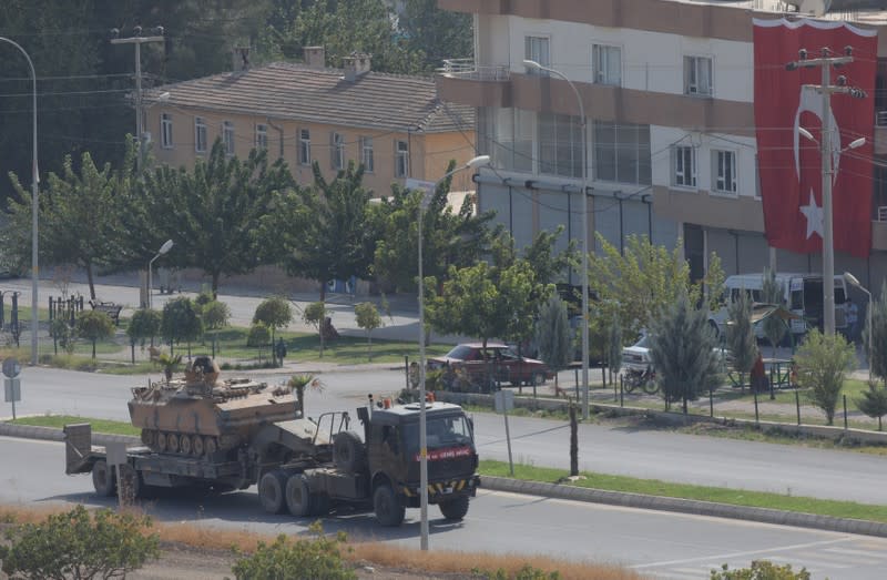 Armoured Turkish army vehicle is transported near the Turkish border town of Ceylanpinar