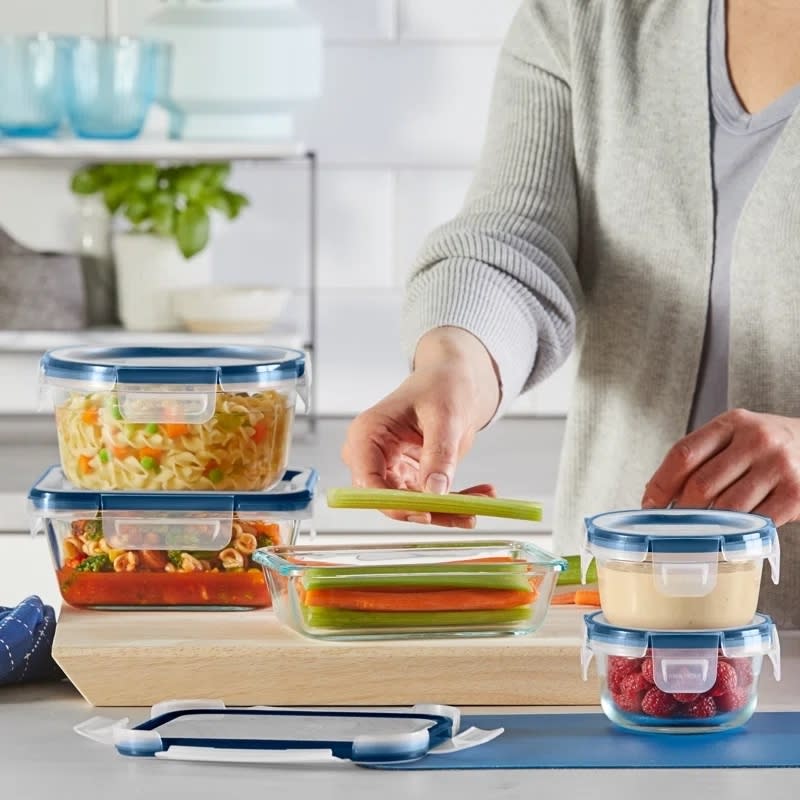 Person placing veggies in one of the containers