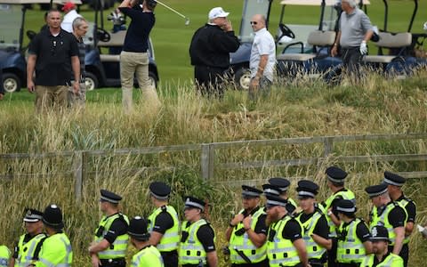 Police secure the area as U.S. President Donald Trump, wearing a hat with Trump and USA displayed on it, plays golf at Trump Turnberry Luxury Collection Resort during the President's first official visit to the United Kingdom - Credit: Getty Images