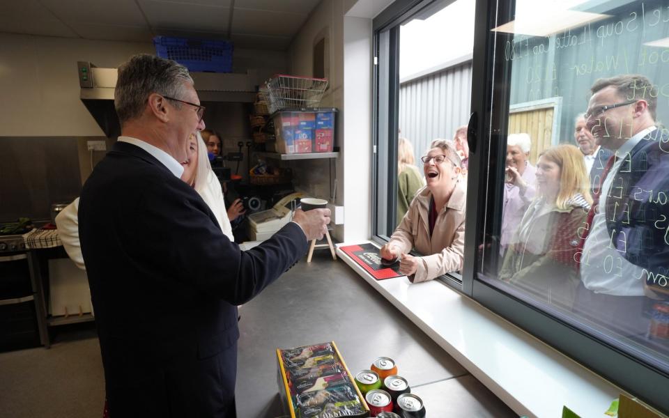 Labour Party leader Sir Keir Starmer serves customers hot beverages during a visit to Hucknall Town FC in Nottinghamshire