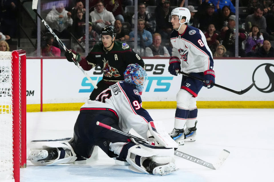 Arizona Coyotes center Nick Schmaltz (8) scores a shorthanded goal against Columbus Blue Jackets goaltender Elvis Merzlikins, left, as defenseman Zach Werenski (8) watches during the third period of an NHL hockey game Tuesday, March 26, 2024, in Tempe, Ariz. The Coyotes won 6-2. (AP Photo/Ross D. Franklin)