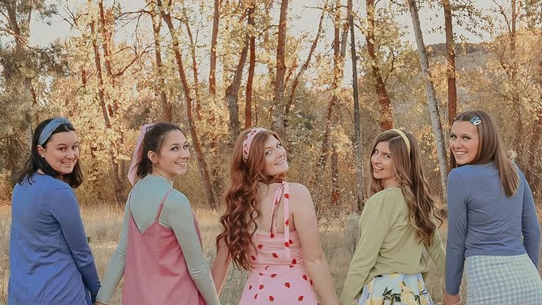 5 young women in a field dressed as strawberry shortcake characters for an 80s group halloween costume