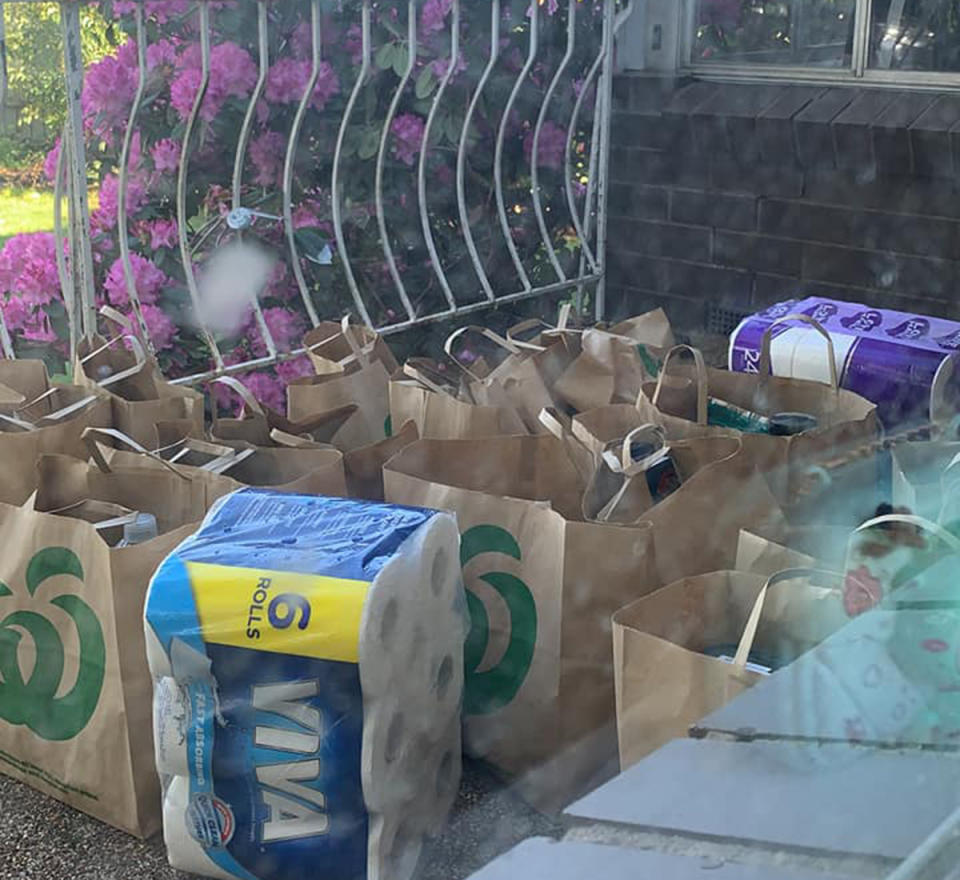 A dozen grocery bags on the ground outside a door. Source: Facebook