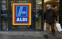 A customer leaves an Aldi supermarket, which has ordered a recall of two frozen prepared meals that had contained horse meat in tests, in northwest London February 9, 2013. REUTERS/Suzanne Plunkett