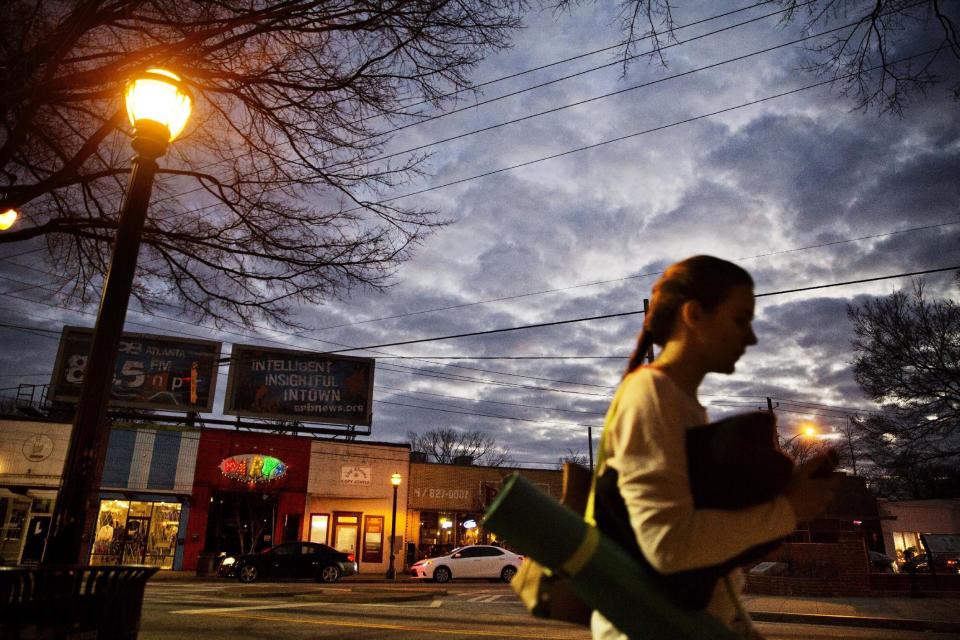 A woman heads to a yoga class as dusk falls in East Atlanta, Ga., in Dekalb County, Wednesday, Jan. 11, 2017. The county is a Democratic stronghold east of downtown Atlanta. Hillary Clinton won four out of five DeKalb votes, capitalizing on a heavy African-American population, a burgeoning Hispanic community and a bevy of white liberals, many of them from elsewhere. (AP Photo/David Goldman)