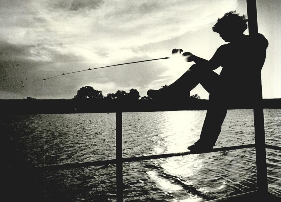 An angler waits for a nibble on his line as he fishes from a pier on Lake Hefner.