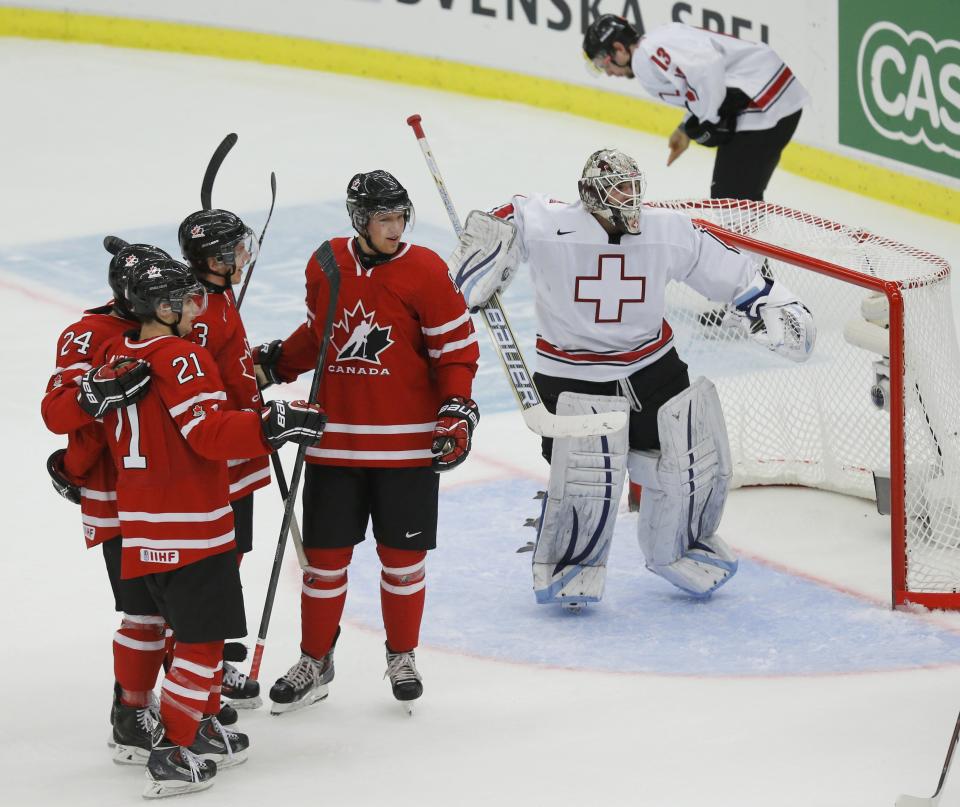 Canada's Griffin Reinhart celebrates his goal on Switzerland's goalie Melvin Nyffeler during the first period of their IIHF World Junior Championship ice hockey game in Malmo