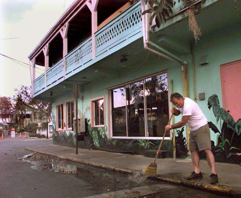 Bill Tsagnis, manager of The Quay Restaurant on Duval Street, sweeps water on a street empty of tourists in October 1998.