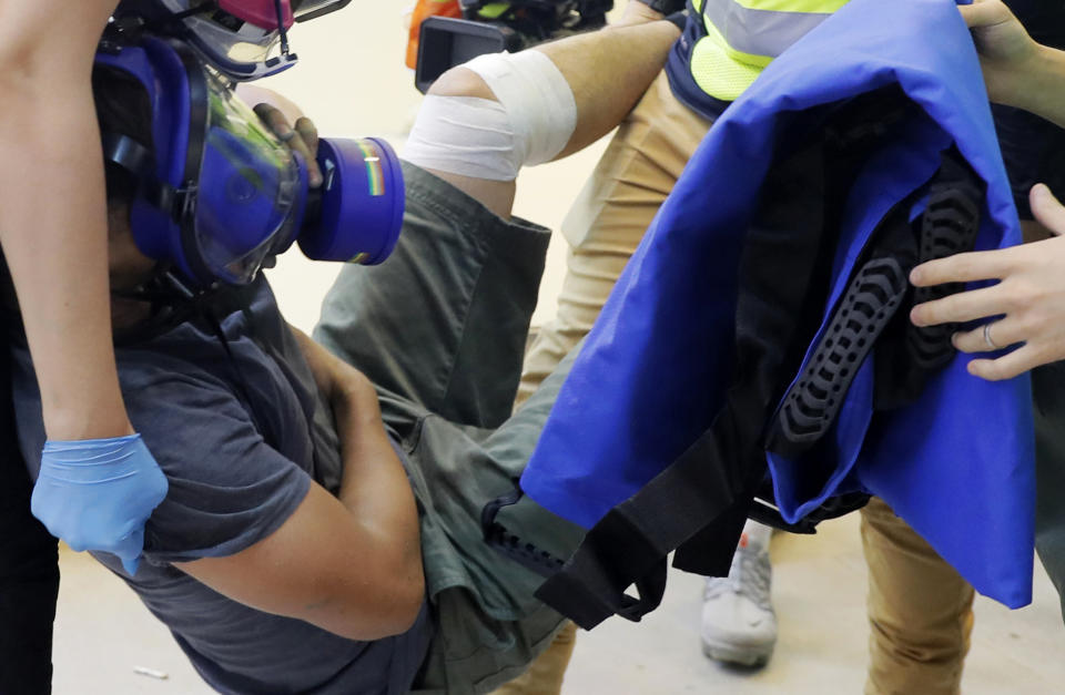 FILE - In this Sept. 15, 2019, file photo, an injured man is carried away during protests in Hong Kong. With Hong Kong’s summer of protests now stretching into the fall and clashes becoming increasingly ferocious, medical professionals have quietly banded together to form the Hidden Clinic and other networks to secretly treat the injuries of many young demonstrators who fear arrest if they go to government hospitals. (AP Photo/Kin Cheung, File)