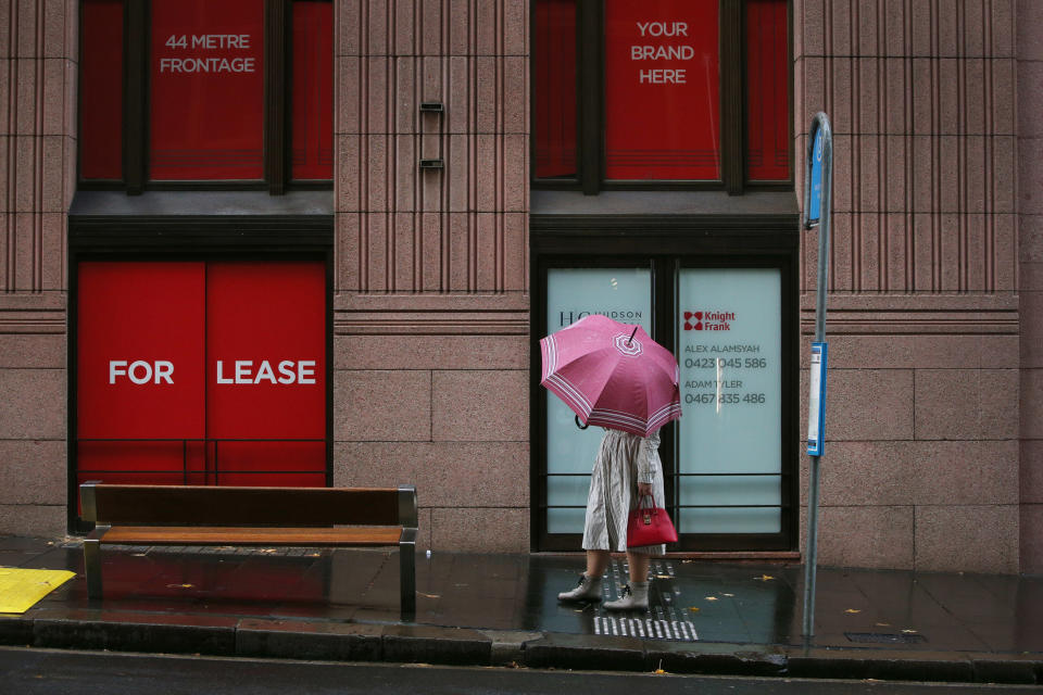 A woman holds an umbrella as she awaits the arrival of a bus in the CBD on June 28, 2021 in Sydney, Australia. 