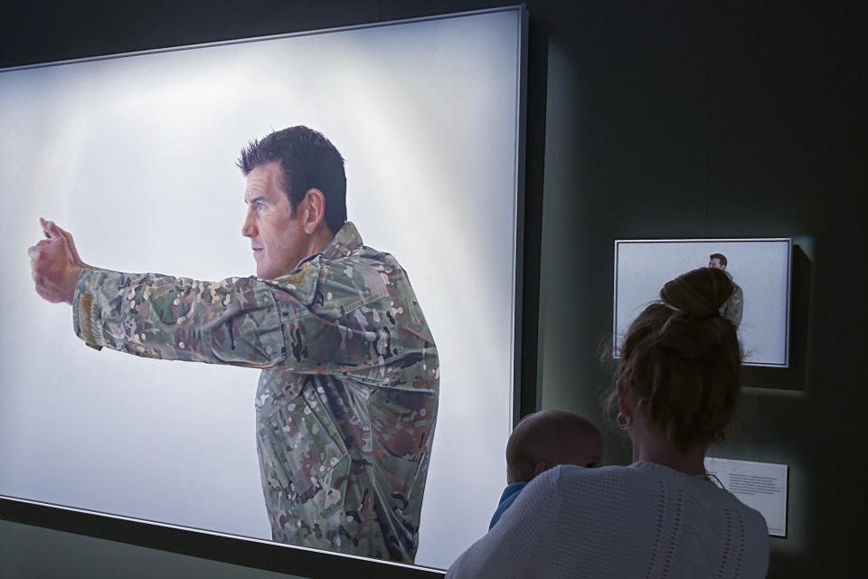 A visitor looks at a display featuring decorated war veteran Ben Roberts-Smith at the Australian War Memorial in Canberra, Australia, Friday, June 2, 2023. A judge concluded Roberts-Smith unlawfully killed prisoners and committed other war crimes in Afghanistan, in a ruling Thursday, June 1 dismissing Roberts-Smith's claims that he was defamed by media reports about his war service. (AP Photo/Rod McGuirk)