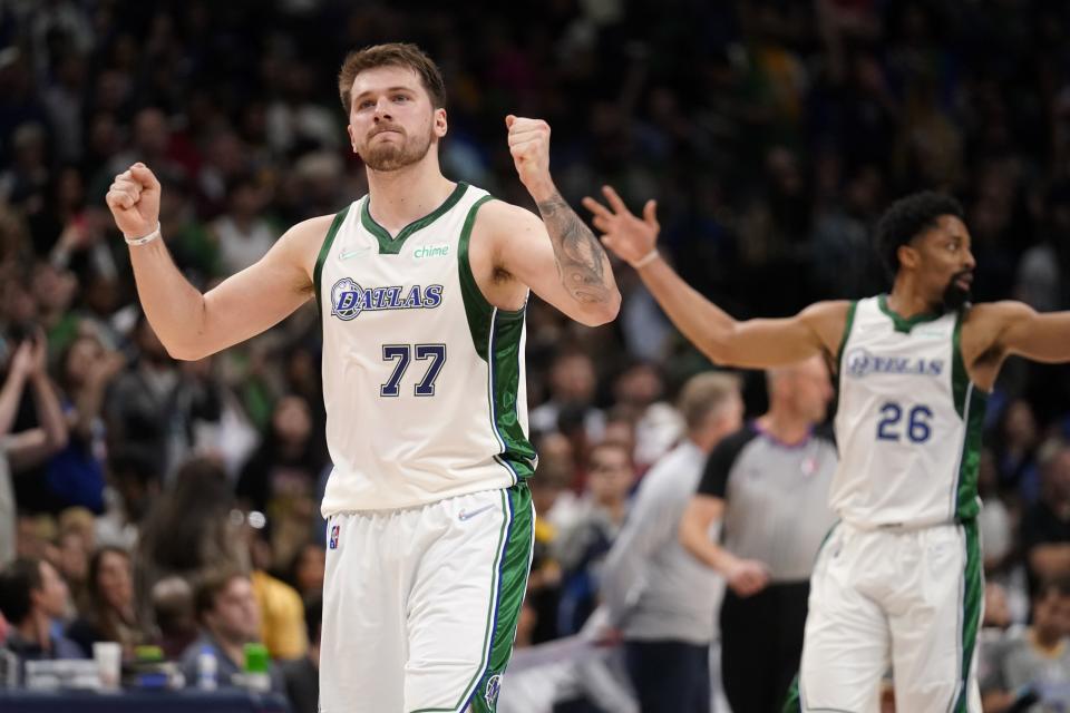 Dallas Mavericks guard Luka Doncic (77) and Spencer Dinwiddie (26) celebrate late in the second half of an NBA basketball game against the Golden State Warriors in Dallas, Thursday, March, 3, 2022. (AP Photo/Tony Gutierrez)