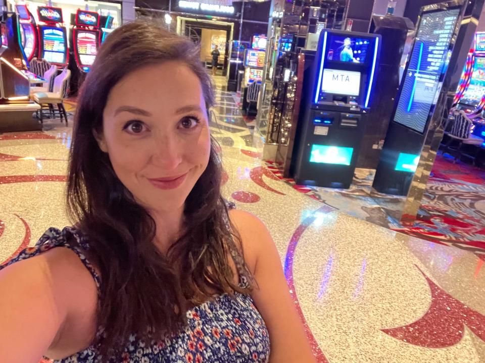 A woman takes a selfie in front of slot machines.