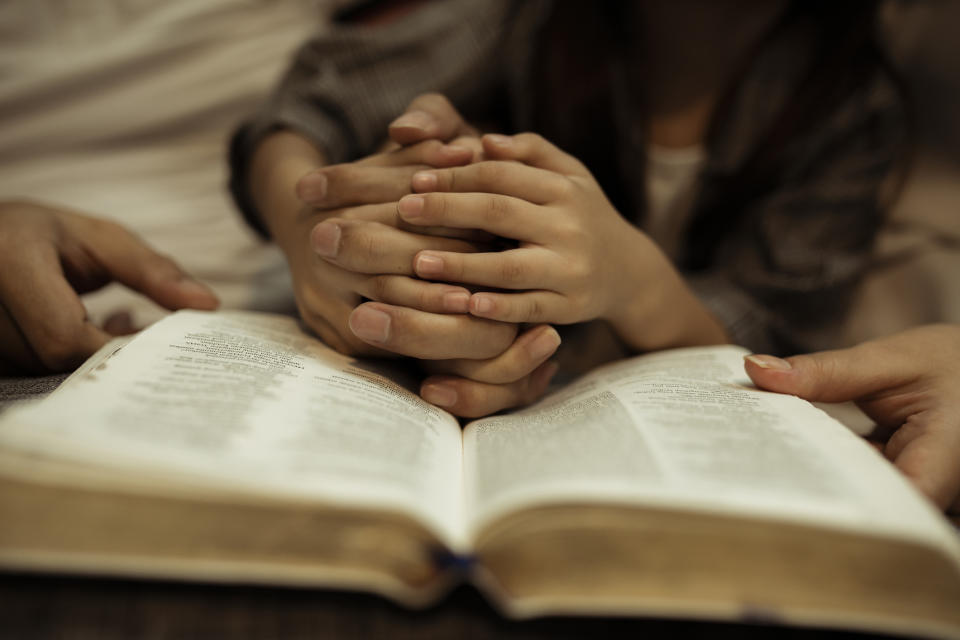 A family is praying over the Bible