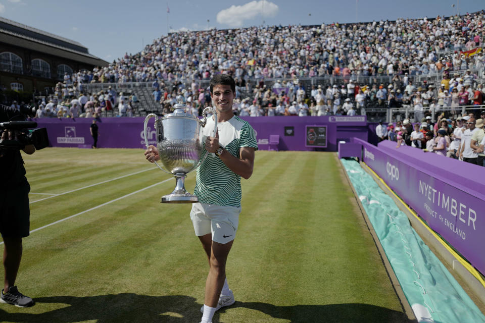 Carlos Alcaraz, of Spain, carries the trophy after defeating Alex de Minaur, of Australia, 6/4, 6/4 in the mens singles final match at the Queens Club tennis tournament in London, Sunday, June 25, 2023. (AP Photo/Alberto Pezzali)