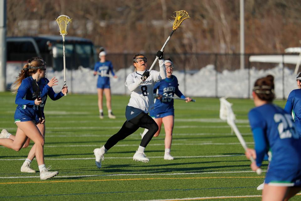 Simmons University grad student Abby Stoller takes the ball up field during a lacrosse game against Salve Regina on March 4, 2022.