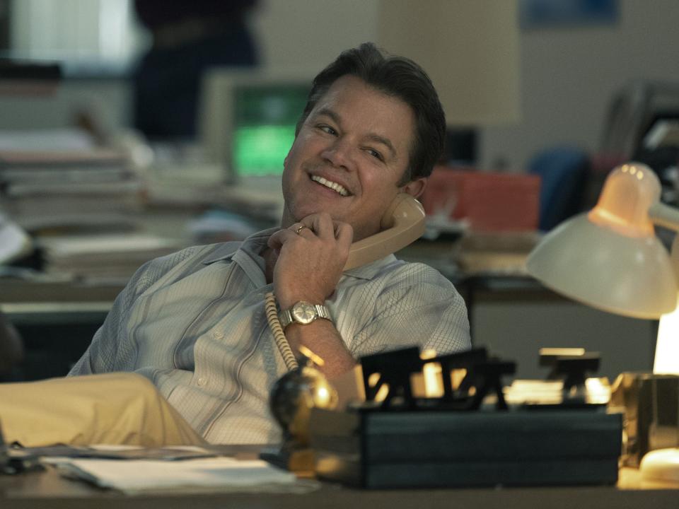 Matt Damon with his legs up at a desk while on the phone