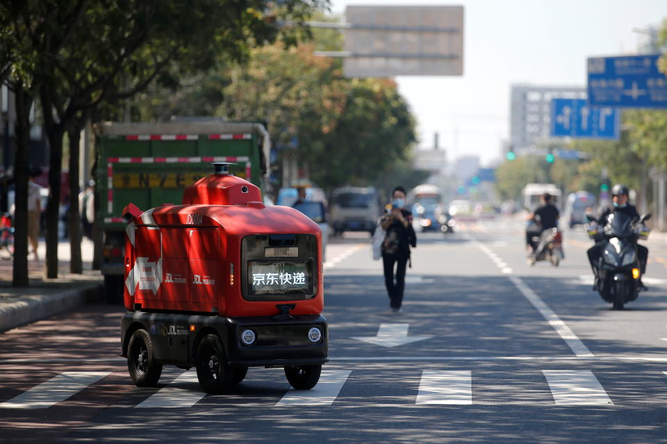 An autonomous delivery vehicle by JD Logistics, the delivery arm of JD.com, operates on a street in Beijing, China September 22, 2021. Picture taken September 22, 2021. REUTERS/Tingshu Wang