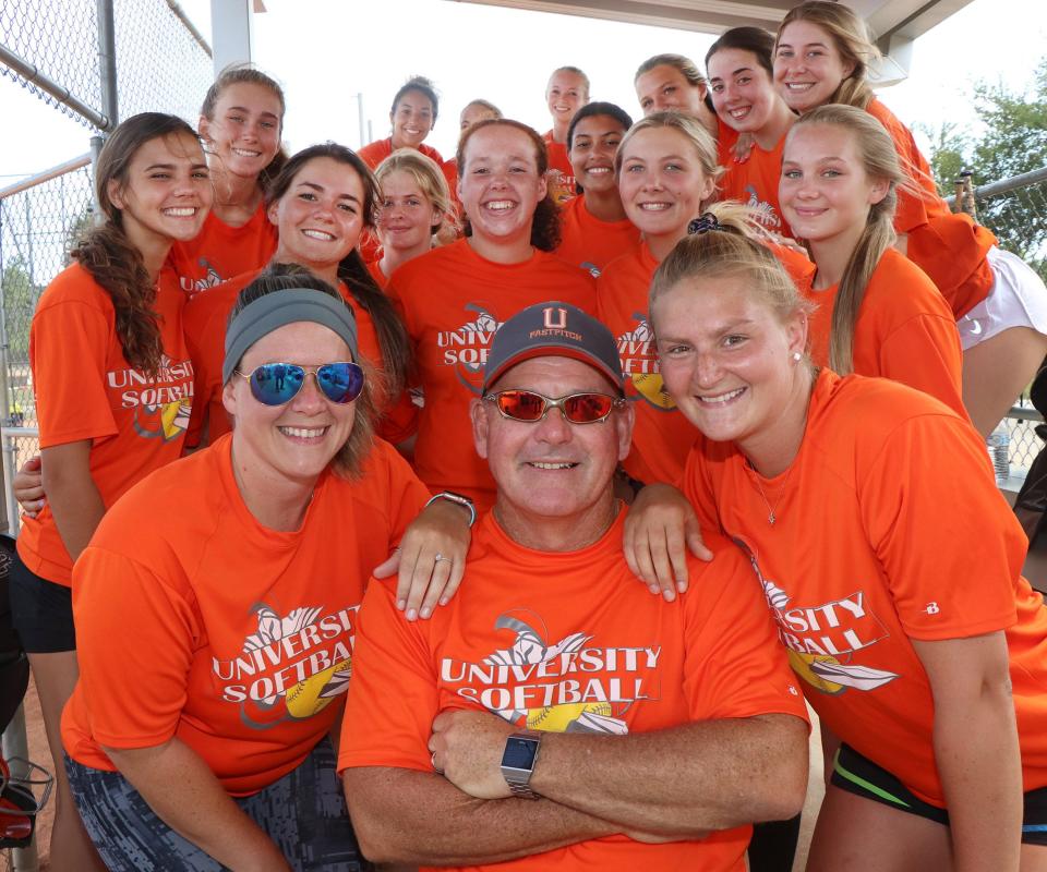 University High softball coach Kenny Walters with assistant coachs/daughters Shelby Walters, at left, and Allison Walters, at right, Wednesday May 19, 2021 with the team of daughter in the background during practice.