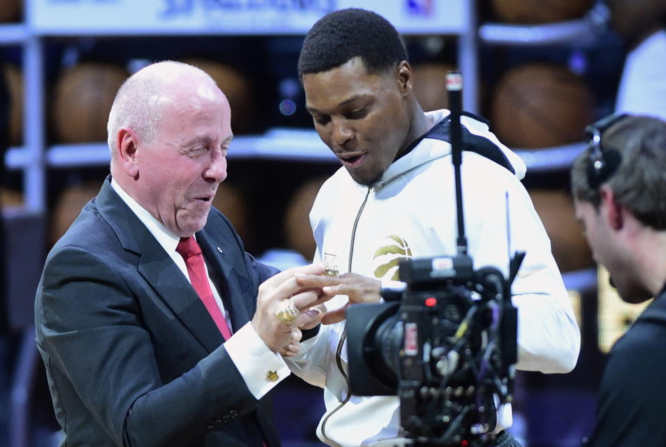 Toronto Raptors guard Kyle Lowry receives his 2019 NBA basketball championship ring from Larry Tanenbaum, chairman of Maple Leaf Sports & Entertainment, before the Raptors played the New Orleans Pelicans in Toronto on Tuesday Oct. 22, 2019. (Frank Gunn/The Canadian Press via AP)