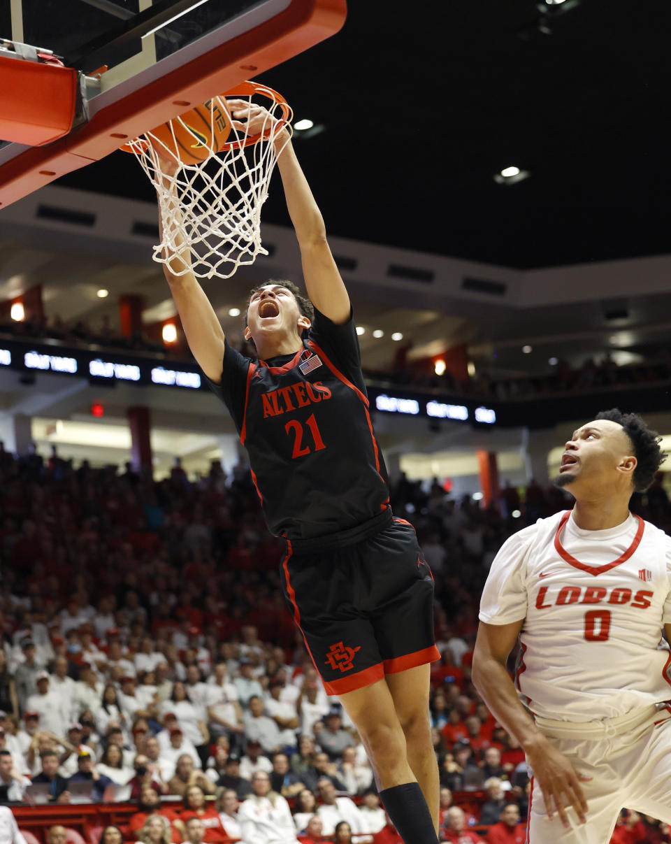 San Diego State guard Miles Byrd dunks in front of New Mexico guard Jemarl Baker Jr. during the first half of an NCAA basketball game, Saturday, Jan. 13, 2024. in Albuquerque, N.M. (AP Photo/Eric Draper)