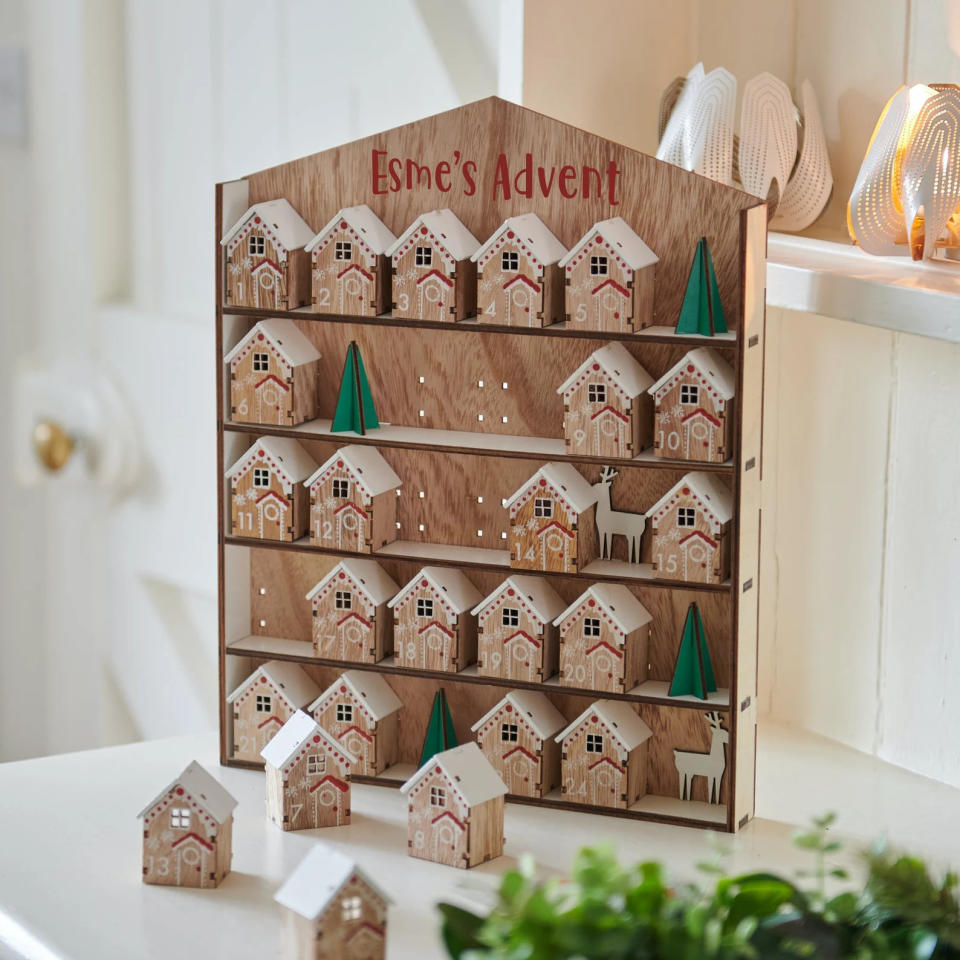 a Personalized Wooden House Advent Calendar on a table
