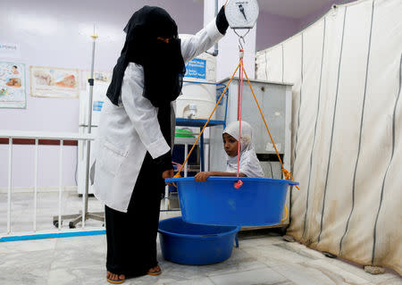 A nurse weighs Afaf Hussein, 10, who is malnourished in Aslam, in the northwestern province of Hajjah, Yemen, February 17, 2019. Afaf, who now weighs around 11 kg and is described by her doctor as "skin and bones", has been left acutely malnourished by a limited diet during her growing years and suffering from hepatitis, likely caused by infected water. She left school two years ago because she got too weak. REUTERS/Khaled Abdullah