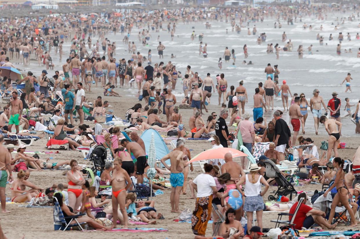 People crowd a beach in Valencia, eastern Spain as a new heatwave hits the country (EPA)