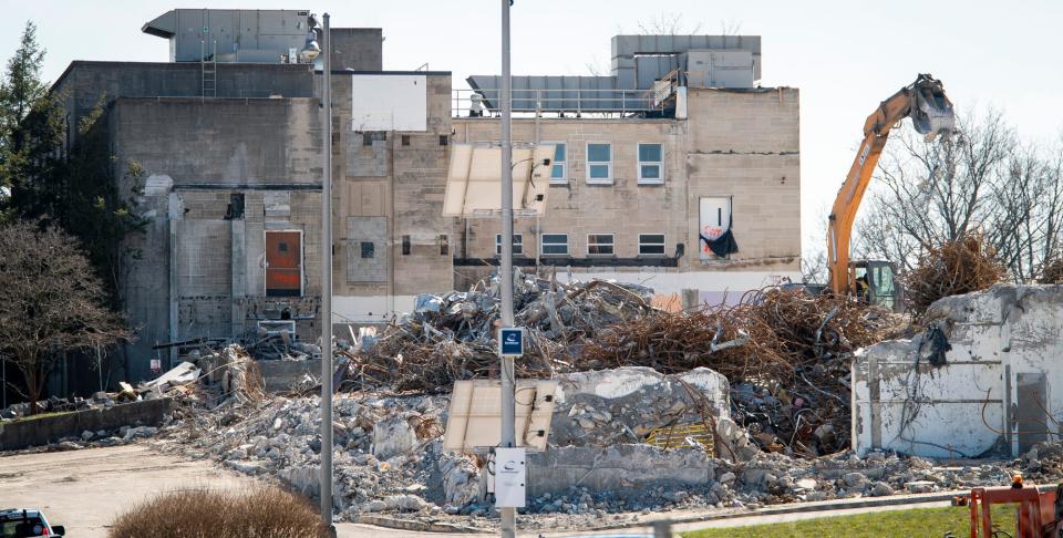 A excavator works on removing debris from the destruction of the old IU Health Bloomington Hospital on Second Street on Tuesday, March 7, 2023.