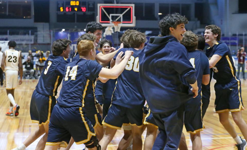 Victor players celebrate after the final buzzer giving them them the win over previously unbeaten Greece Athena 70-61 in their boys basketball Section V Class AA sectional final game Saturday, March 2, 2024 at the Blue Cross Arena in Rochester.