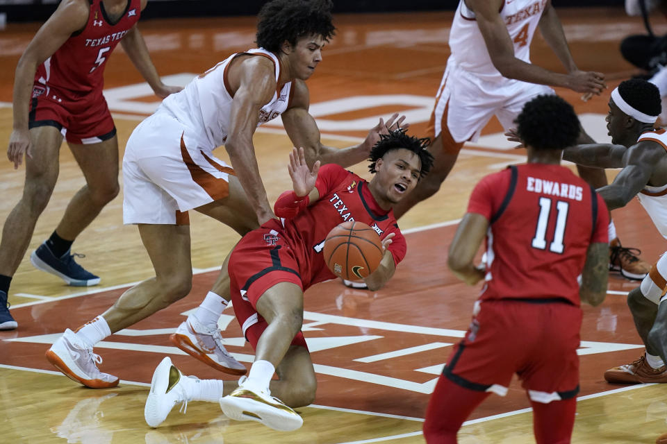 Texas Tech guard Terrence Shannon Jr. (1) passes the ball away from Texas forward Jericho Sims (20) as he loses his balance during the second half of an NCAA college basketball game Wednesday, Jan. 13, 2021, in Austin, Texas. (AP Photo/Eric Gay)