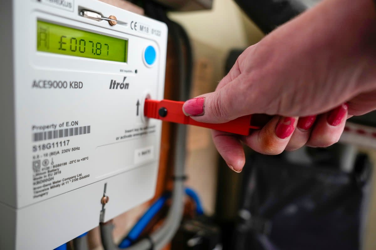 File photo: A woman tops up a prepayment meter (Getty)