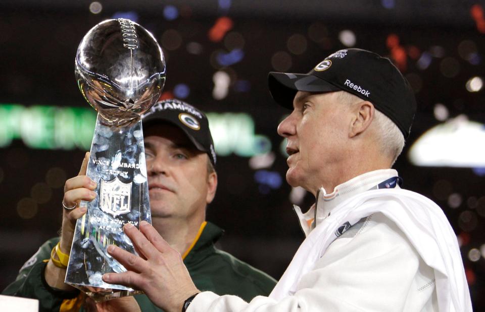 Green Bay Packers coach Mike McCarthy, left, and General Manager Ted Thompson look at the Vince Lombardi trophy after the Packers beat the Pittsburgh Steelers, 31-25, in Super Bowl XLV on Feb. 6, 2011, in Arlington, Texas.