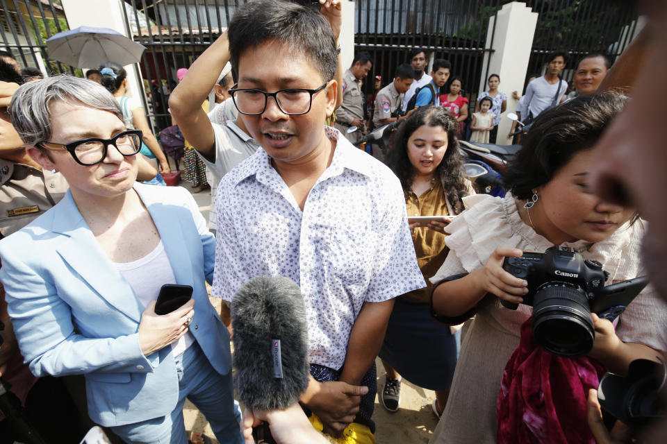 Reuters reporter Wa Lone, center, speaks to media after he is freed from Insein Prison in Yangon, Myanmar, Tuesday, May 7, 2019. Two Reuters journalists who were imprisoned for breaking Myanmar's Official Secrets Act over reporting on security forces' abuses of Rohingya Muslims were pardoned and released Tuesday, the prison chief and witnesses said. (Ann Wang/Pool Photo via AP)