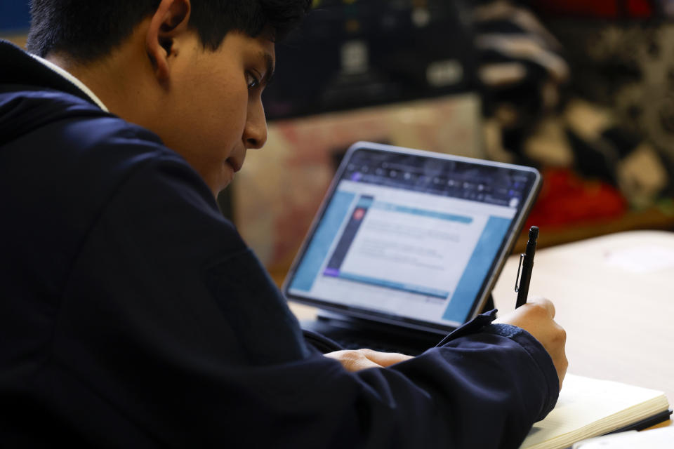 Elijah Nicolas Hernandez-Valeriano takes notes to prepare himself for the digital SAT, Wednesday, March 6, 2024, at Holy Family Cristo Rey Catholic High School in Birmingham, Ala. (AP Photo/Butch Dill)