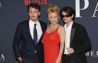 Il avait été annoncé en mars 2022, par la plateforme de streaming Netflix. Le documentaire « Pamela Anderson, a love story » se dévoile enfin au public ce mardi 31 janvier. Dédié à la carrière et à la vie personnelle de Pamela Anderson, le programme de près de deux heures revient notamment sur l’enfance difficile de la star, son ascension sur le devant de la scène grâce à la série « Alerte à Malibu » mais aussi sur les déboires qui l’ont forgée au fil des années. Un documentaire évènement dont l’actrice de 55 ans fait pleinement la promotion. Ce lundi 30 janvier, elle était d’ailleurs au Netflix Tudum Theater de Los Angeles pour la grande avant-première.Lire aussi : Histoire d’une tenue : le maillot de bain rouge de Pamela Anderson dans « Alerte à Malibu » Parée d’une robe flamboyante, rappelant indéniablement son célèbre maillot de bain rouge dans « Alerte à Malibu », Pamela Anderson a pu compter sur des soutiens de taille durant l’évènement. En effet, ses deux fils, Brandon et Dylan, se tenaient à ses côtés pour la soutenir. Une rare apparition familiale que les photographes n’ont pas manqué d’immortaliser, tandis que Paris Jackson, la fille de Michael Jackson, se présentait elle aussi devant les flashs. Pamela Anderson et Tommy LeeAprès avoir connu une idylle avec David Charvet, son partenaire à l’écran dans « Alerte à Malibu », au début des années 90, Pamela Anderson a retrouvé l’amour dans les bras de Tommy Lee en 1995 et ensemble, ils ont vécu une histoire des plus tumultueuses. Et pour cause. En 1995, une vidéo de leurs états amoureux, filmés durant leur lune de miel, était dérobée et mise en ligne, créant un véritable scandale à Hollywood. Le début d’une bataille judiciaire visant à faire interdire sa diffusion pour les deux stars, mais pas la fin de leur romance passionnelle pour autant. Un an plus tard, Pamela Anderson et Tommy Lee accueillent leur premier enfant ensemble, Brandon. Puis un second, Dylan, en 1997. Les deux stars finiront par mettre un terme à leur histoire en 1998.Ecoutez notre podcast sur Pamela Anderson :