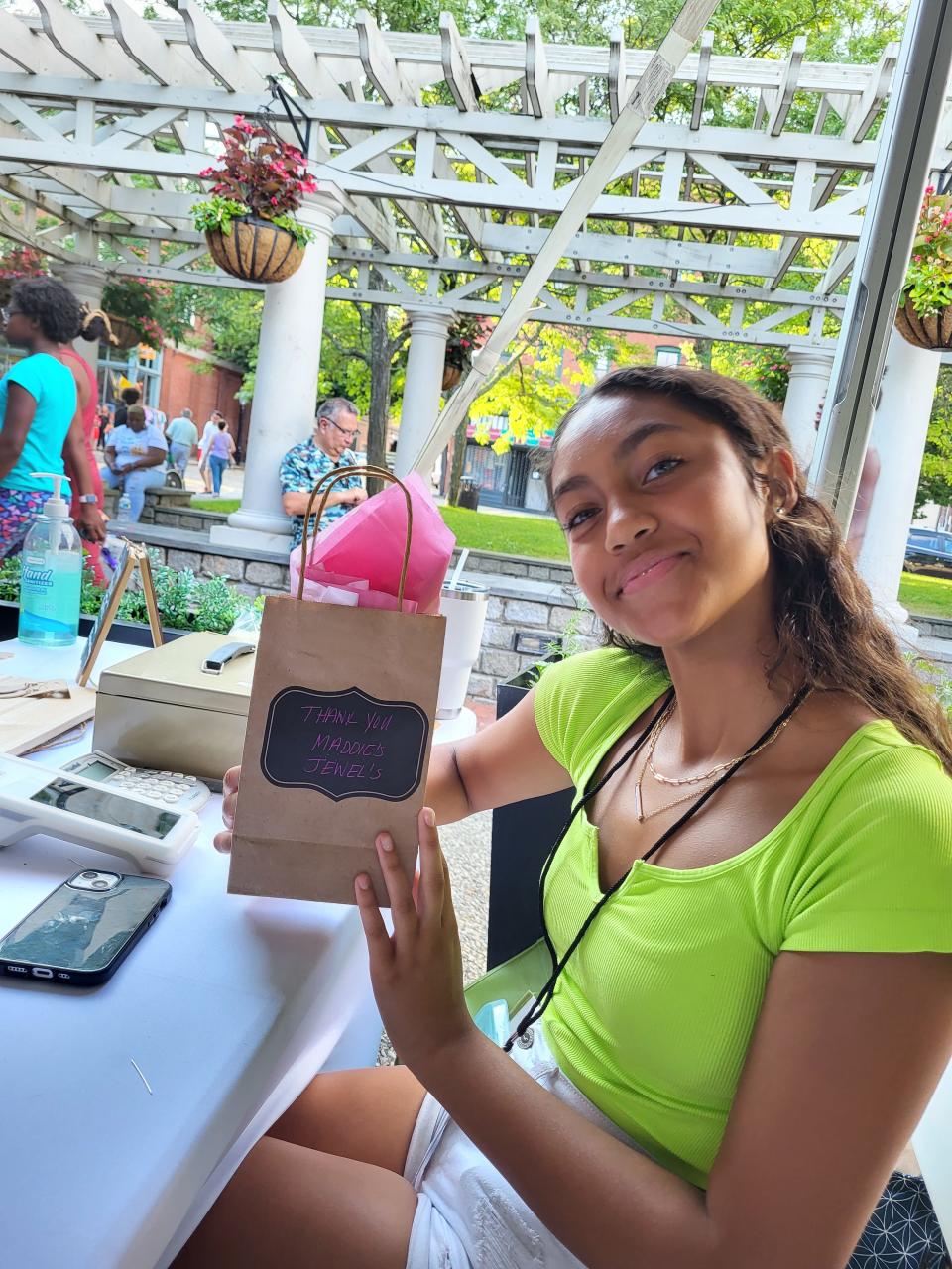 Madison Alves, 14, of Dartmouth, tends to her table selling earrings at the Dream Makers Market on Thursday, July 14, at Wing's Court in downtown New Bedford.