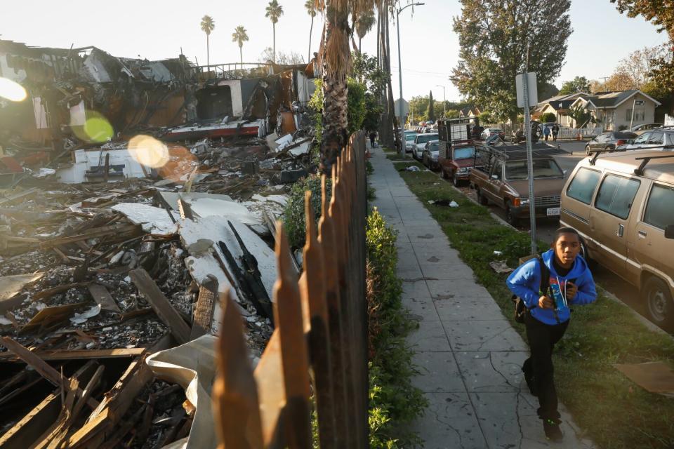 A boy walks past the remains of Victory Baptist Church.